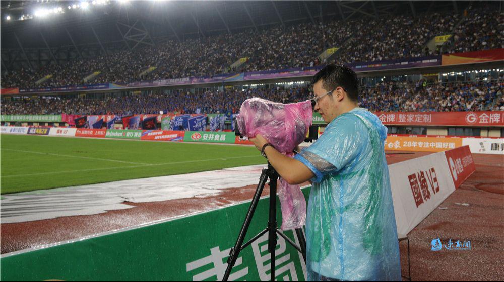 星空体育平台-主场内外看“苏超”·热力直击丨雨中“护枪人”：幕后记者用雨衣裹住设备坚持“战斗”